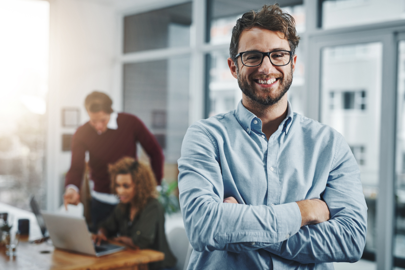 Confident managers create successful teams. Portrait of a confident young man with his colleagues in the background at work.